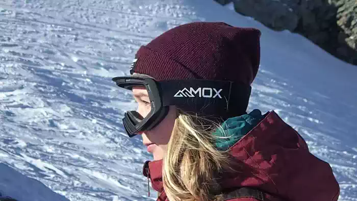A demonstration of ski goggles with a magnetic quick-change system for swapping lenses.